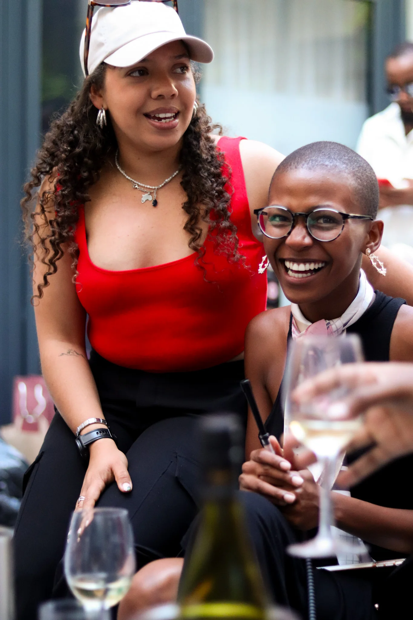 coloured girl in red and girl seated